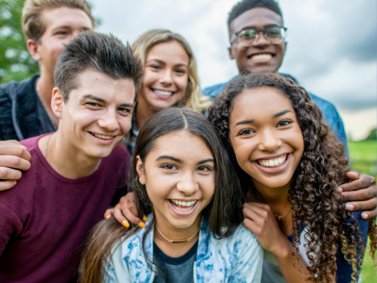 A group of smiling young people outdoors